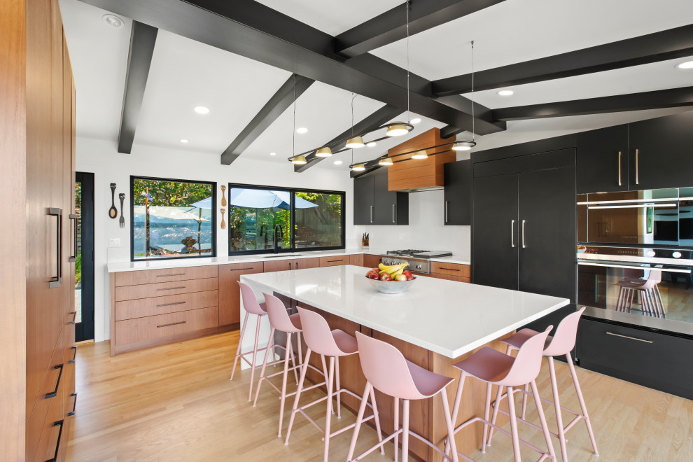 Inspiration for a large 1950s l-shaped medium tone wood floor and exposed beam enclosed kitchen remodel in Seattle with an undermount sink, flat-panel cabinets, medium tone wood cabinets, quartz countertops, white backsplash, quartz backsplash, paneled appliances, an island and white countertops