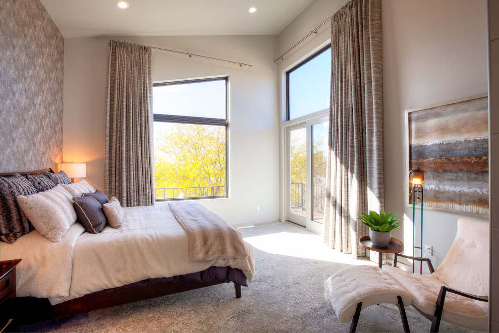 На фото: большая хозяйская спальня в стиле модернизм с белыми стенами, ковровым покрытием, двусторонним камином, фасадом камина из плитки и обоями на стенах