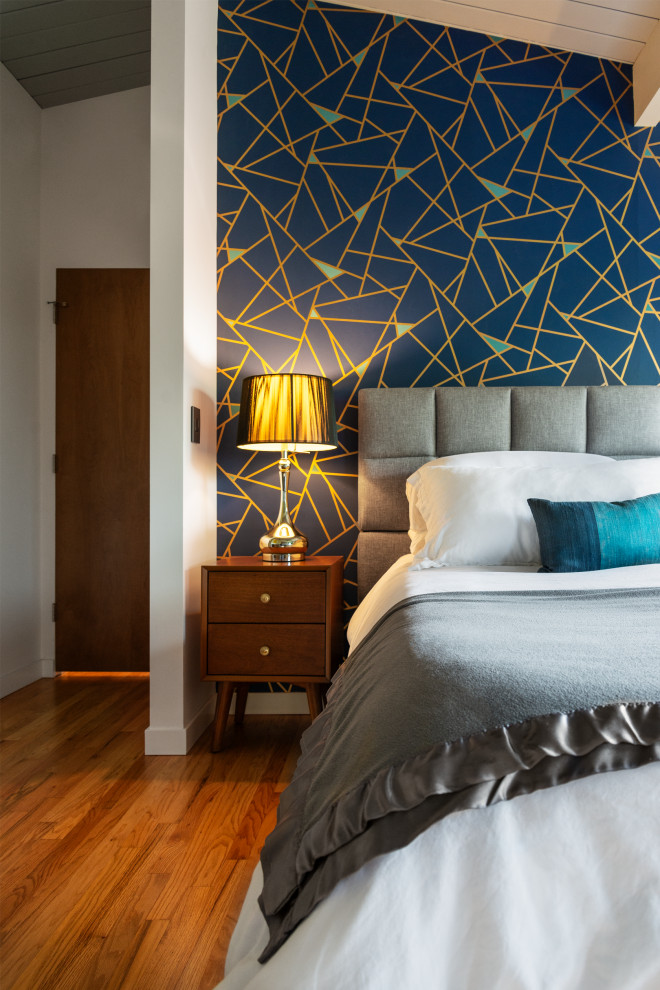 Immagine di una camera matrimoniale minimalista di medie dimensioni con pareti blu, parquet chiaro, soffitto in legno e carta da parati