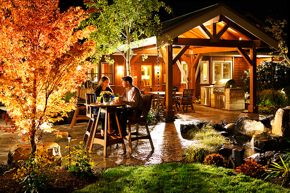 Example of a mid-sized mountain style backyard stone patio kitchen design in Seattle with a gazebo