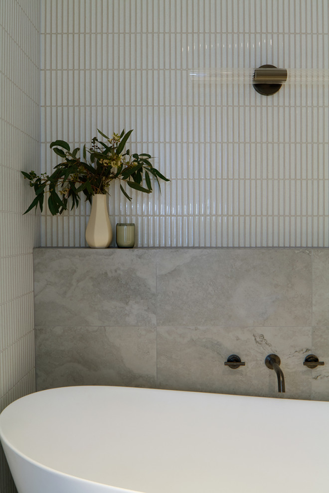 Idéer för att renovera ett mellanstort funkis vit vitt en-suite badrum, med skåp i shakerstil, vita skåp, ett fristående badkar, en öppen dusch, en toalettstol med hel cisternkåpa, vit kakel, travertinkakel, vita väggar, travertin golv, ett undermonterad handfat, marmorbänkskiva, flerfärgat golv och med dusch som är öppen