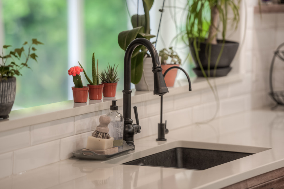 Transitional l-shaped kitchen photo in Toronto with an undermount sink, shaker cabinets, light wood cabinets, white backsplash, stainless steel appliances, an island and white countertops