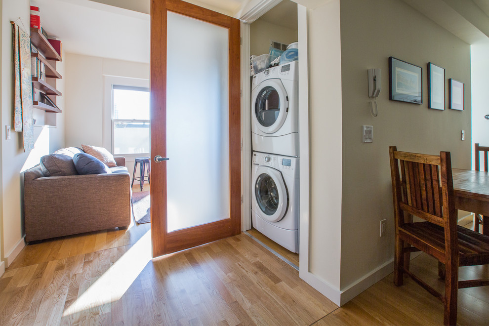 Design ideas for a small transitional laundry cupboard in San Francisco with a stacked washer and dryer.
