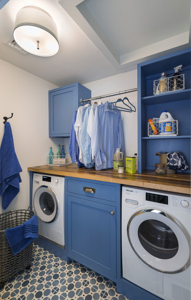 Design ideas for a small country single-wall utility room in Providence with beaded inset cabinets, blue cabinets, wood benchtops, white walls, porcelain floors, an integrated washer and dryer, blue floor and brown benchtop.