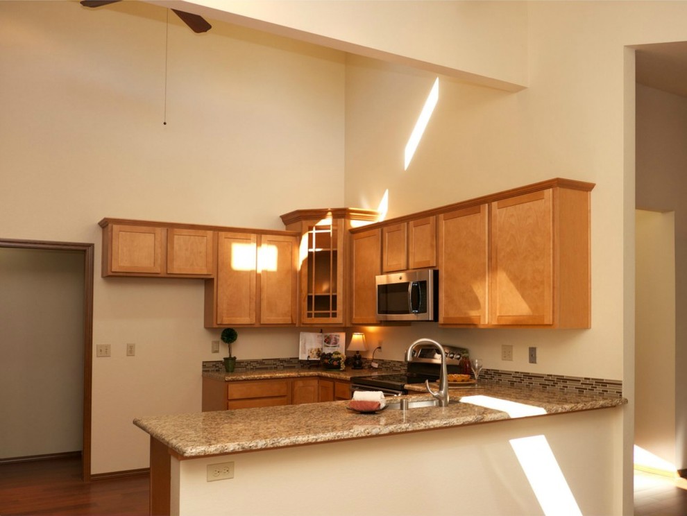 Kitchen - mid-sized transitional u-shaped bamboo floor kitchen idea in Seattle with an undermount sink, recessed-panel cabinets, light wood cabinets, granite countertops, multicolored backsplash, stainless steel appliances, beige walls and a peninsula