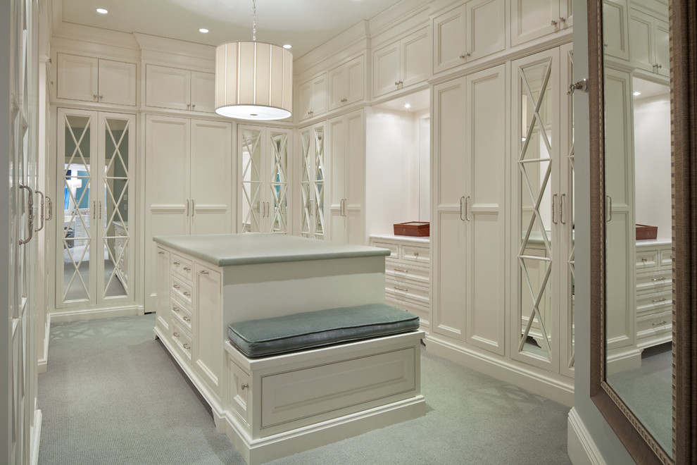 This is an example of a traditional gender-neutral walk-in wardrobe in Columbus with beaded inset cabinets, white cabinets and carpet.