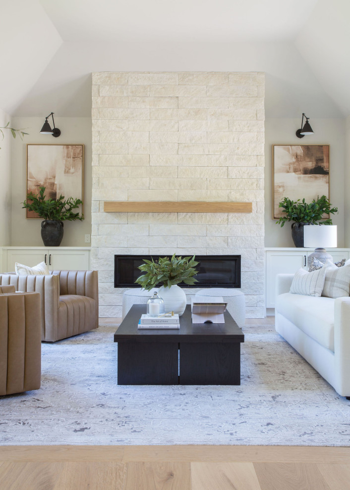 Large transitional open concept light wood floor, vaulted ceiling and wainscoting living room photo in Seattle with gray walls, a standard fireplace and a stacked stone fireplace