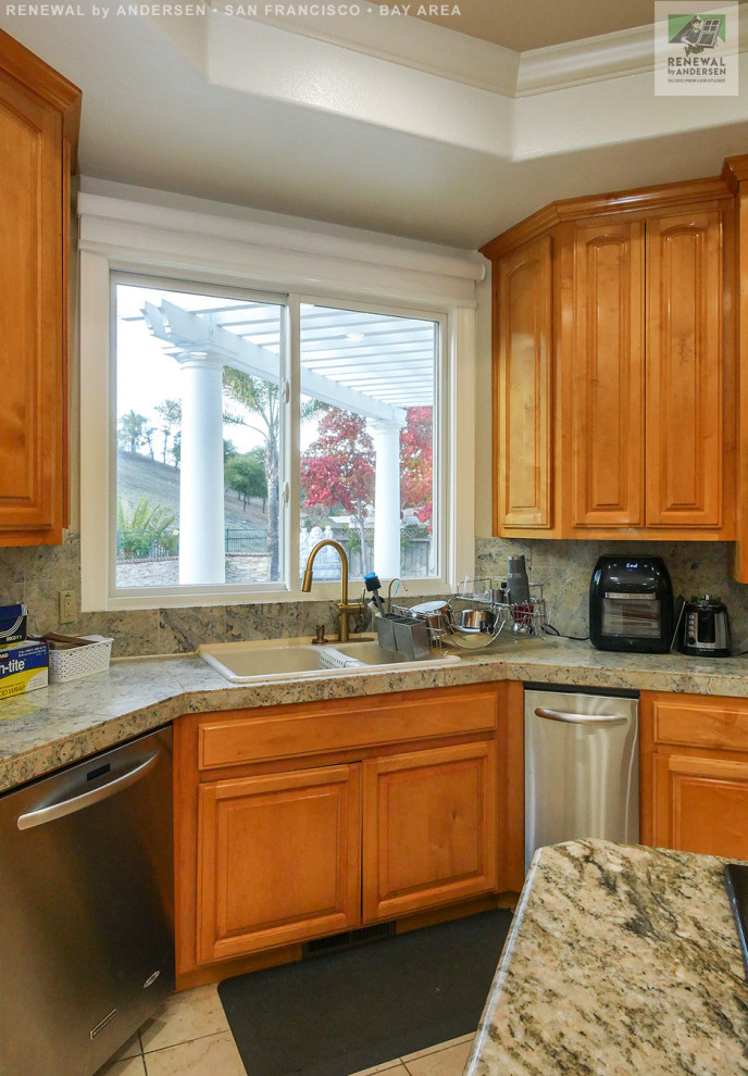 Example of a large l-shaped ceramic tile, beige floor and tray ceiling eat-in kitchen design in San Francisco with a drop-in sink, medium tone wood cabinets, granite countertops, multicolored backsplash, stainless steel appliances, an island and multicolored countertops