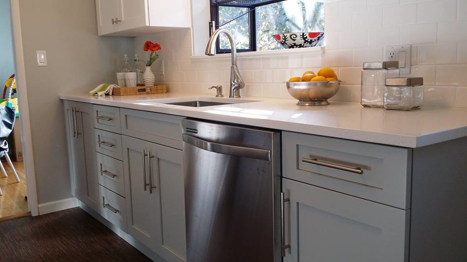This is an example of a small transitional galley separate kitchen in Seattle with an undermount sink, shaker cabinets, white cabinets, quartzite benchtops, white splashback, subway tile splashback, stainless steel appliances and medium hardwood floors.