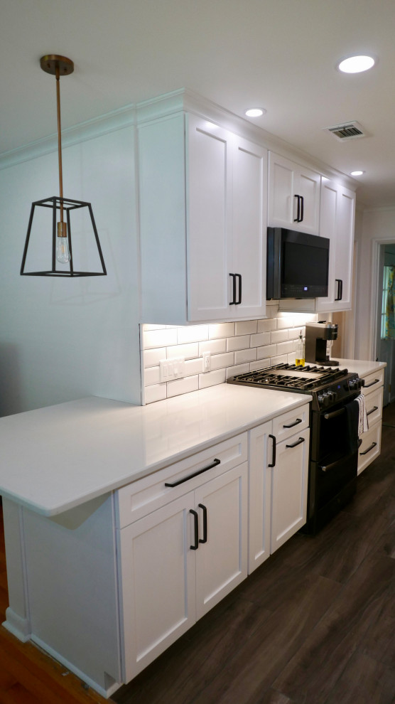 Eat-in kitchen - mid-sized transitional galley porcelain tile and gray floor eat-in kitchen idea with an undermount sink, shaker cabinets, white cabinets, quartz countertops, white backsplash, subway tile backsplash, black appliances, no island and white countertops