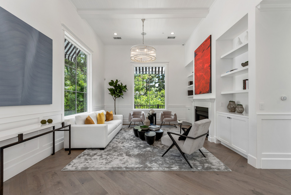 Inspiration for a transitional formal open concept living room in Los Angeles with white walls, medium hardwood floors, a standard fireplace, no tv, brown floor, exposed beam, timber and panelled walls.