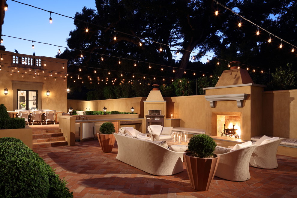 Design ideas for a mediterranean patio in Los Angeles with tile, no cover and with fireplace.