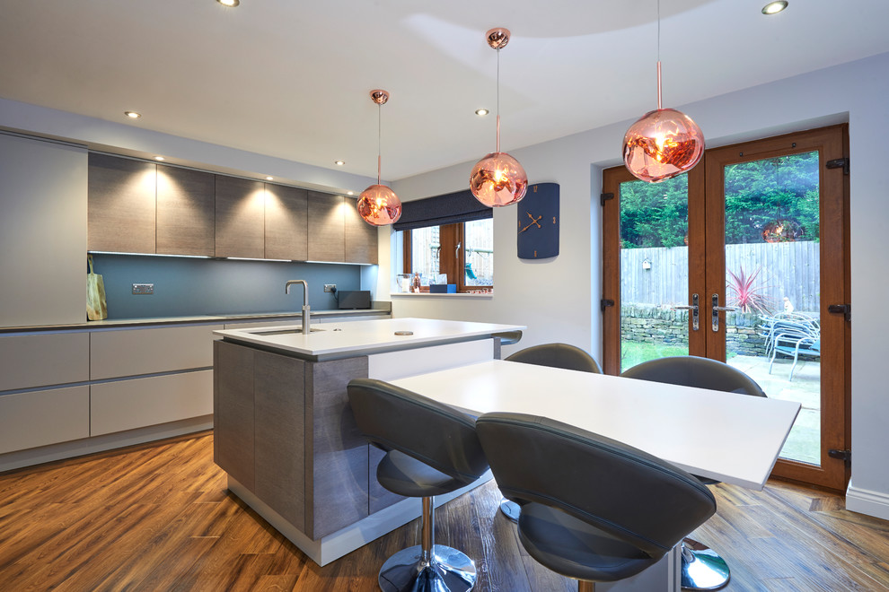 Design ideas for a contemporary galley eat-in kitchen in Other with an undermount sink, flat-panel cabinets, grey cabinets, blue splashback, medium hardwood floors, with island, brown floor and white benchtop.