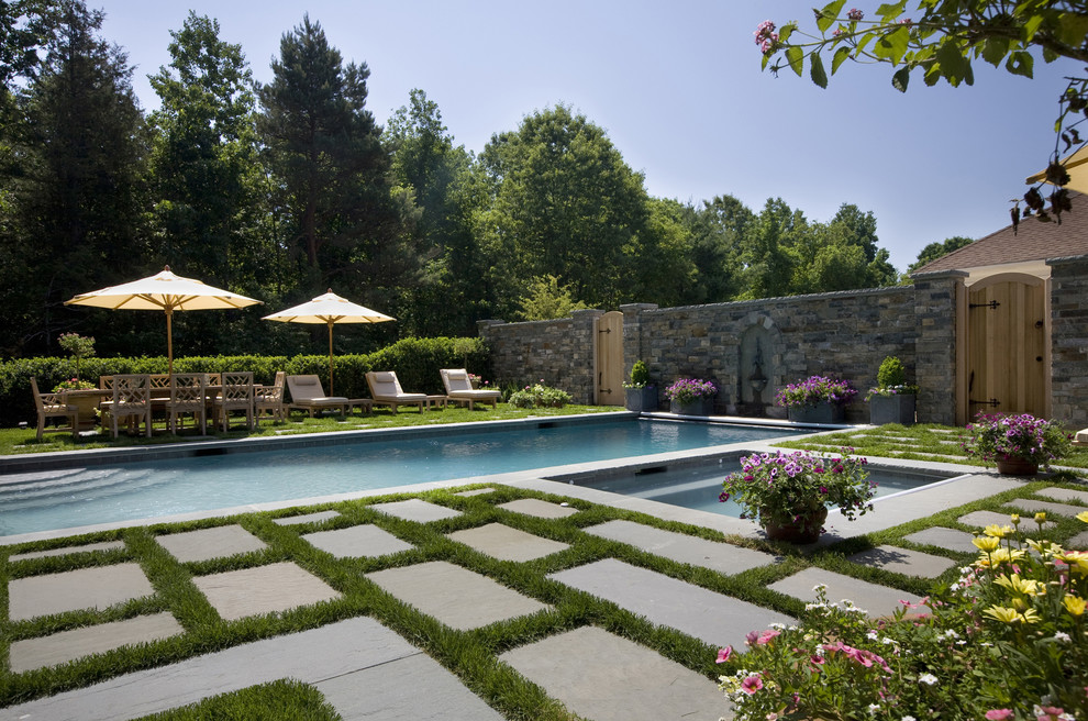 Photo of a large traditional rectangular pool in Boston with natural stone pavers.