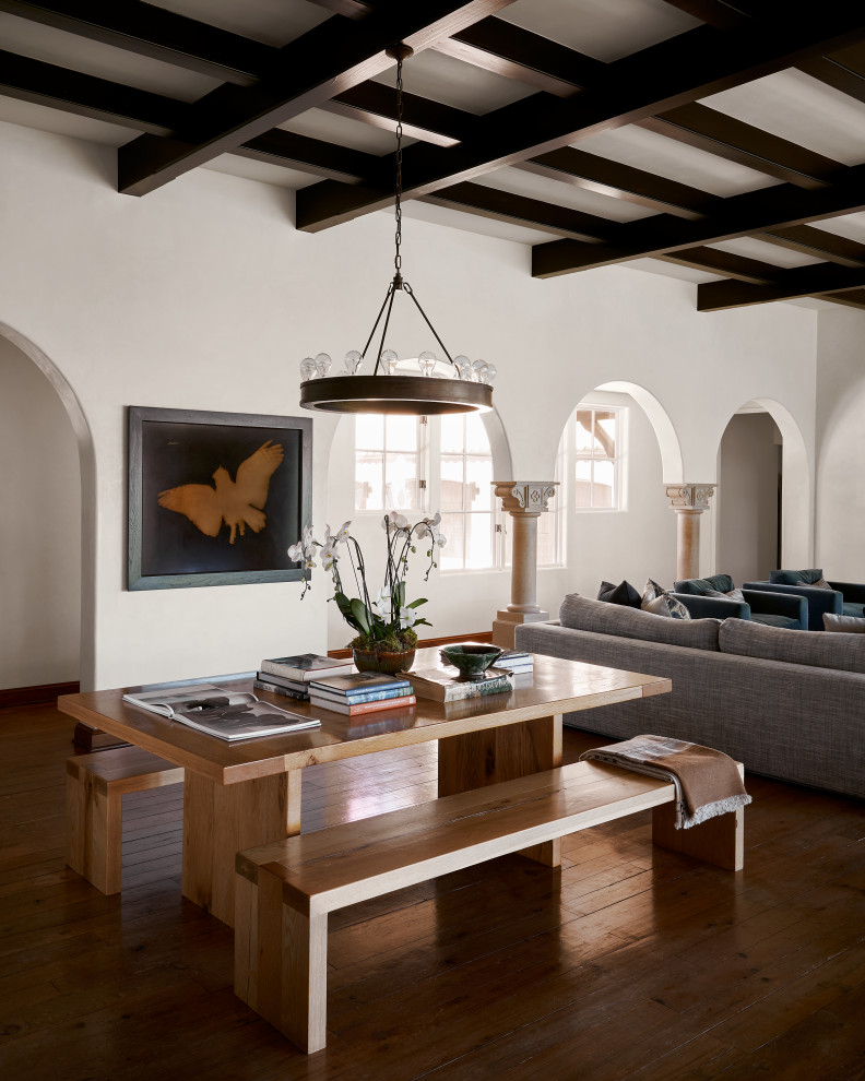 Immagine di un'ampia sala da pranzo mediterranea con pareti bianche, pavimento in legno massello medio, pavimento marrone e travi a vista
