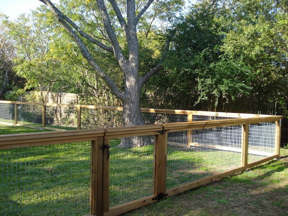 Mid-sized traditional backyard full sun garden in Austin with a retaining wall for spring.