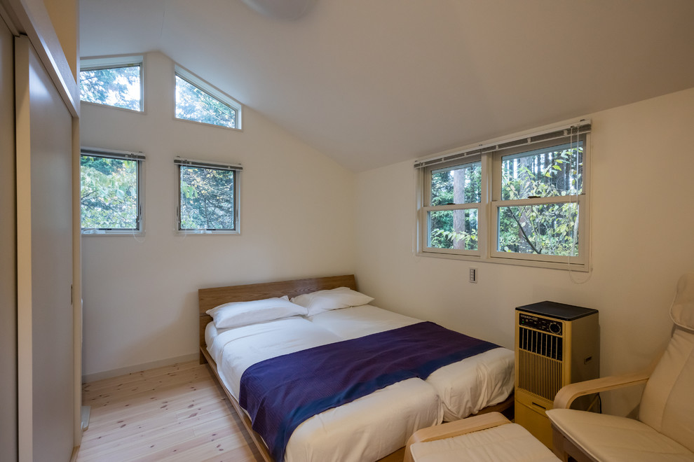 他の地域にあるカントリー風のおしゃれな寝室 (白い壁、淡色無垢フローリング、茶色い床) のインテリア
