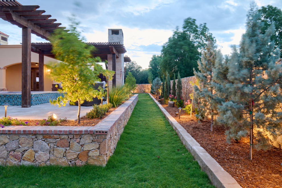 Idee per un giardino mediterraneo esposto in pieno sole di medie dimensioni e dietro casa con pavimentazioni in pietra naturale e recinzione in pietra