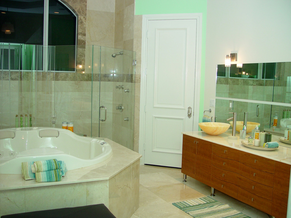 Design ideas for a mid-sized contemporary master bathroom in Miami with furniture-like cabinets, medium wood cabinets, a hot tub, an open shower, a one-piece toilet, beige tile, mirror tile, white walls, marble floors, a trough sink and quartzite benchtops.