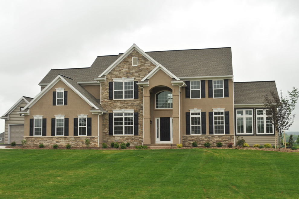 Large elegant two-story beige home design photo