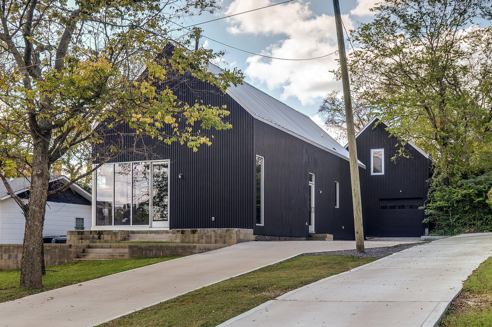 This is an example of a mid-sized modern two-storey black exterior in Nashville with concrete fiberboard siding and a gable roof.