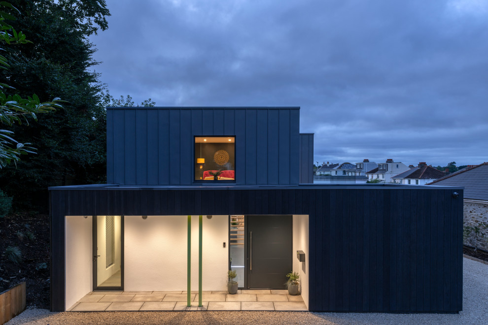 Inspiration for a small contemporary two-storey black house exterior in Devon with metal siding and a flat roof.