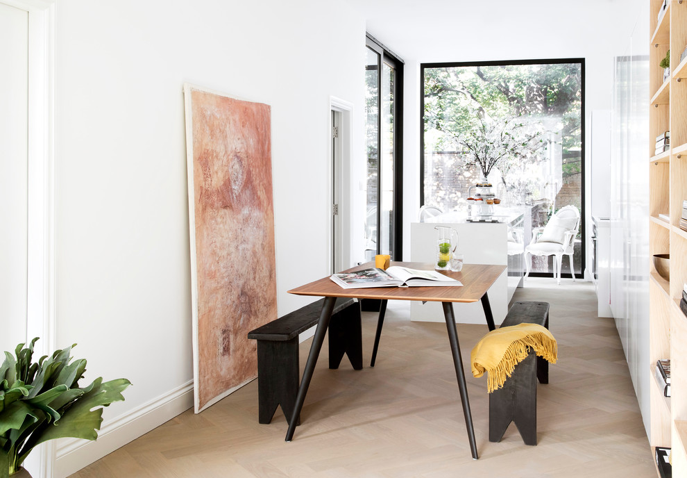 This is an example of a mid-sized contemporary dining room in London with white walls and light hardwood floors.