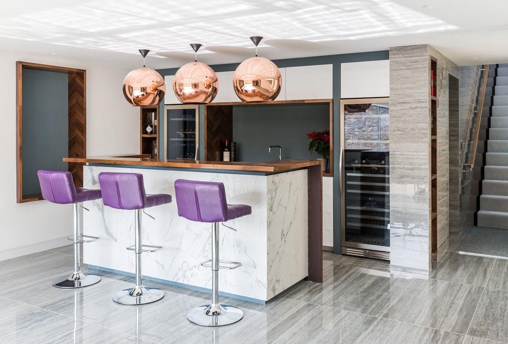 This is an example of a contemporary home bar in Kent with flat-panel cabinets, white cabinets, black splashback and grey floor.