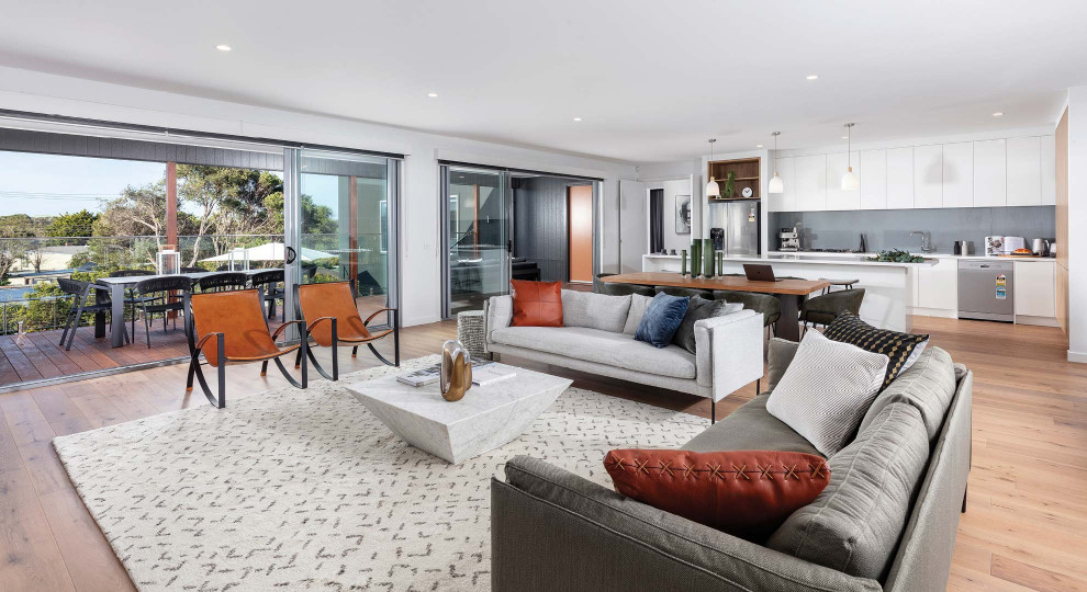 Photo of a contemporary open concept living room in Melbourne with white walls, medium hardwood floors and brown floor.