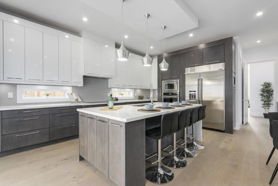 Inspiration for a mid-sized modern l-shaped open plan kitchen in Vancouver with a double-bowl sink, flat-panel cabinets, grey cabinets, quartz benchtops, window splashback, stainless steel appliances, light hardwood floors, with island, beige floor and white benchtop.