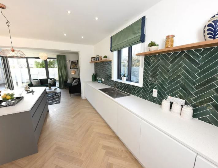 Inspiration for an expansive contemporary l-shaped open plan kitchen in Cork with a double-bowl sink, flat-panel cabinets, grey cabinets, green splashback, porcelain splashback, coloured appliances, laminate floors, with island, beige floor and white benchtop.