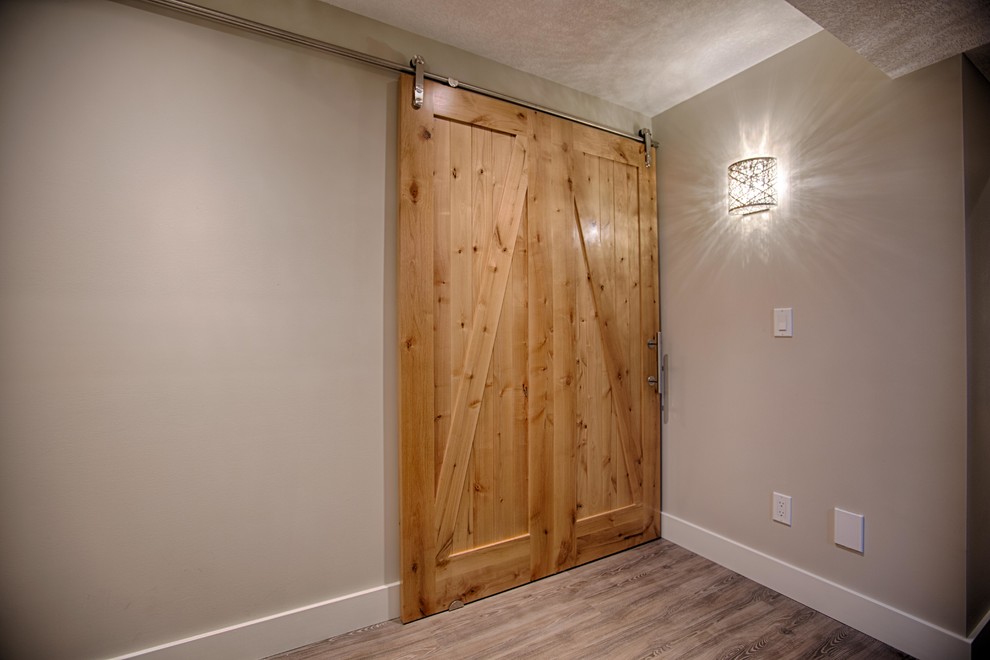 Basement - large rustic look-out light wood floor basement idea in Calgary with white walls, a standard fireplace and a brick fireplace