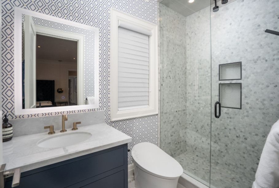 Inspiration for a small modern 3/4 bathroom in Toronto with flat-panel cabinets, blue cabinets, an open shower, a one-piece toilet, multi-coloured tile, porcelain floors, an undermount sink, quartzite benchtops, a hinged shower door, grey benchtops, marble and blue walls.