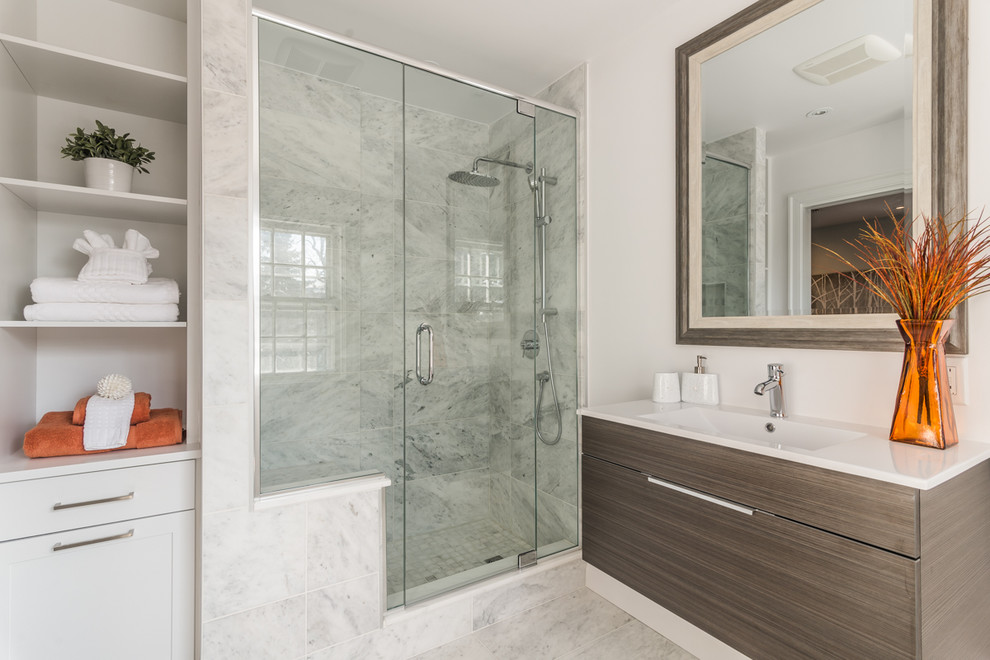 Design ideas for a mid-sized contemporary master bathroom in Montreal with an integrated sink, flat-panel cabinets, dark wood cabinets, engineered quartz benchtops, an alcove shower, white tile, stone tile, white walls and marble floors.