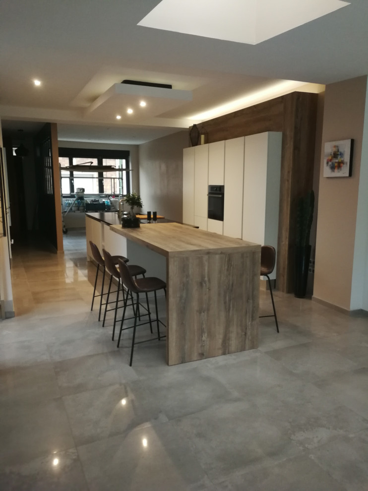 This is an example of a large contemporary galley open plan kitchen in Other with an integrated sink, granite worktops, an island and black worktops.
