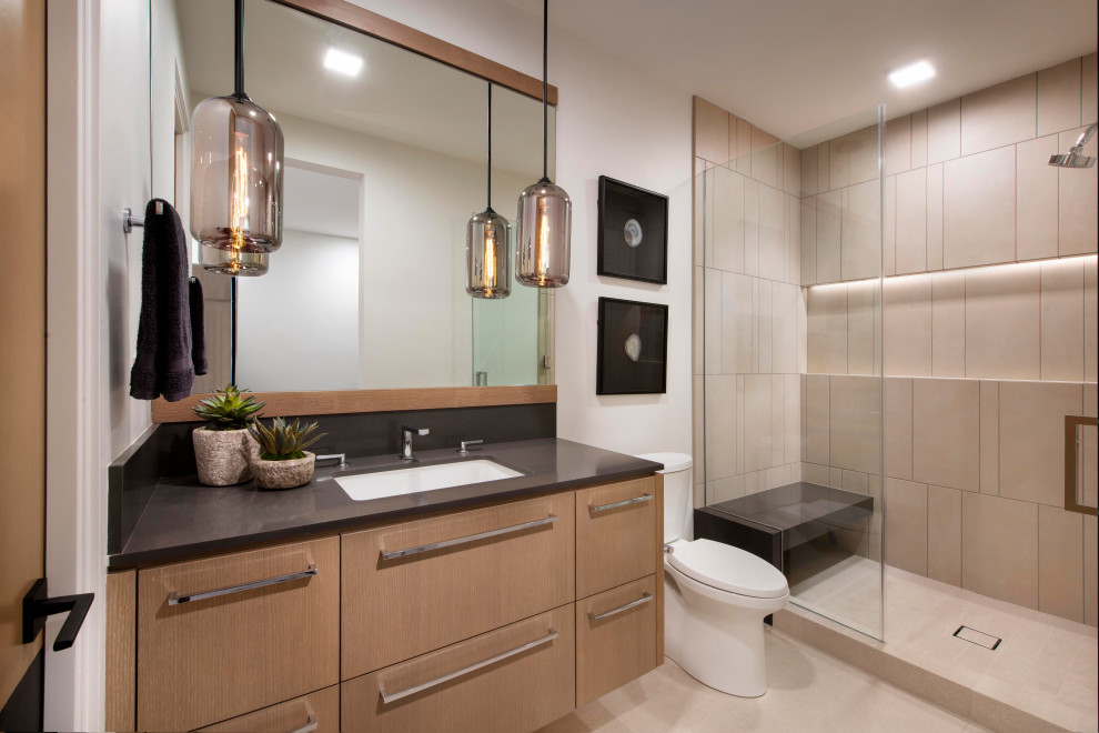 Inspiration for a large modern 3/4 wet room bathroom in Phoenix with flat-panel cabinets, a two-piece toilet, beige tile, stone tile, grey walls, an integrated sink, quartzite benchtops, beige floor, black benchtops, a shower seat, a single vanity and a floating vanity.