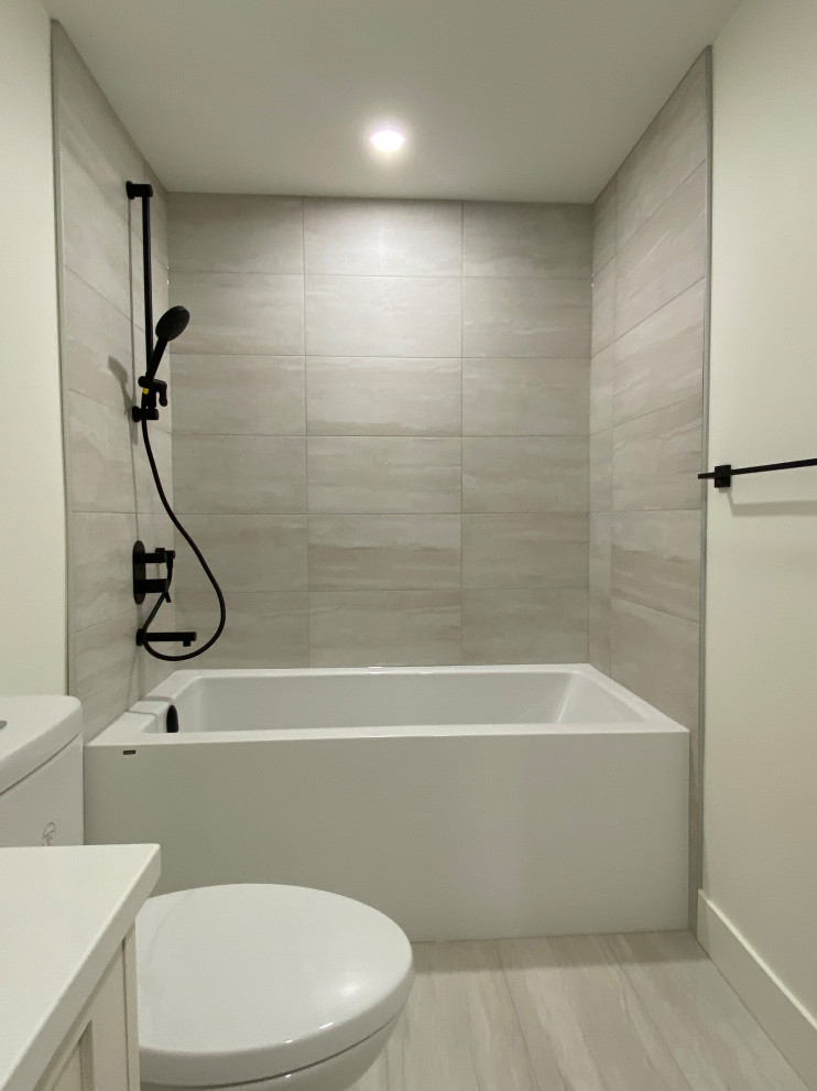 На фото: ванная комната среднего размера в стиле неоклассика (современная классика) с белыми фасадами, серой плиткой, белой столешницей и встроенной тумбой