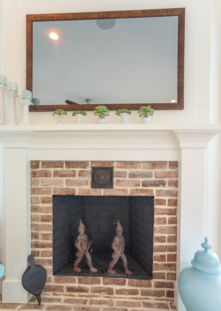 Mid-sized beach style enclosed family room in Atlanta with white walls, medium hardwood floors, a corner fireplace, a brick fireplace surround, no tv and brown floor.