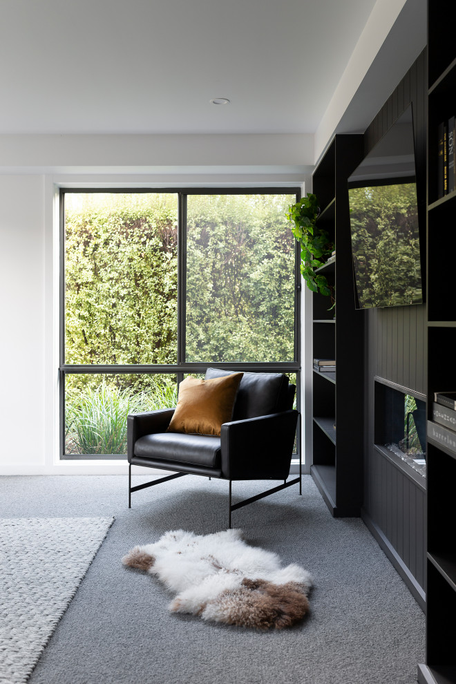 Exemple d'une petite salle de séjour moderne ouverte avec une bibliothèque ou un coin lecture, un mur noir, moquette, une cheminée ribbon, un téléviseur encastré et un sol gris.