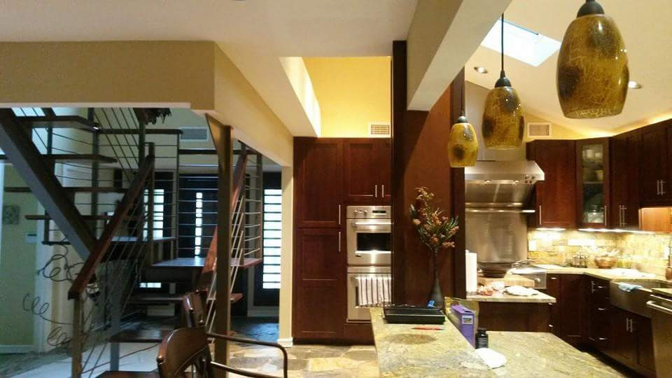 Large mountain style l-shaped marble floor, multicolored floor and vaulted ceiling eat-in kitchen photo in Austin with a farmhouse sink, shaker cabinets, dark wood cabinets, granite countertops, multicolored backsplash, marble backsplash, stainless steel appliances, two islands and multicolored countertops