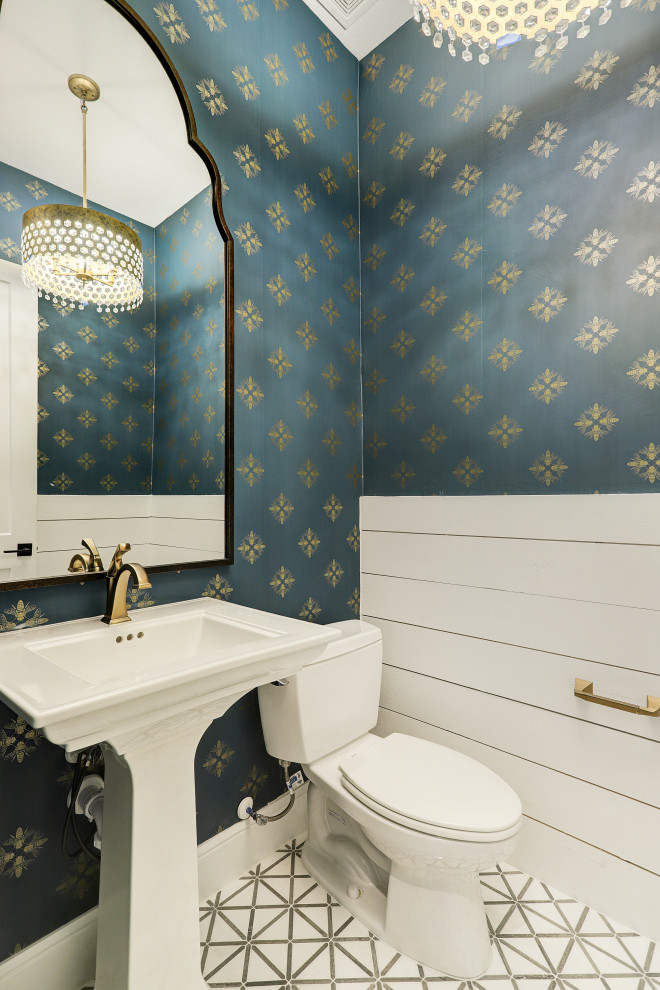 Klassische Gästetoilette mit weißen Schränken, Toilette mit Aufsatzspülkasten, blauer Wandfarbe, Mosaik-Bodenfliesen, Wandwaschbecken, weißem Boden, freistehendem Waschtisch und Tapetenwänden in Houston