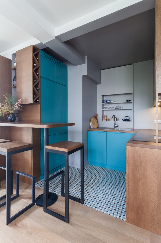 Small contemporary u-shaped eat-in kitchen in Paris with an integrated sink, beaded inset cabinets, wood benchtops, grey splashback, panelled appliances, ceramic floors, no island, multi-coloured floor and dark wood cabinets.