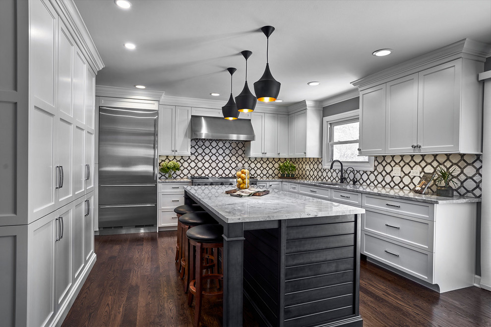 Example of a large transitional l-shaped dark wood floor and brown floor open concept kitchen design in Chicago with an undermount sink, recessed-panel cabinets, white cabinets, quartzite countertops, white backsplash, marble backsplash, stainless steel appliances, an island and gray countertops