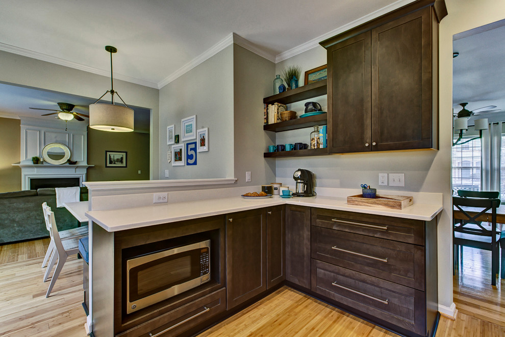 Example of a mid-sized transitional l-shaped bamboo floor eat-in kitchen design in Raleigh with a double-bowl sink, shaker cabinets, dark wood cabinets, quartz countertops, white backsplash, ceramic backsplash, stainless steel appliances and no island
