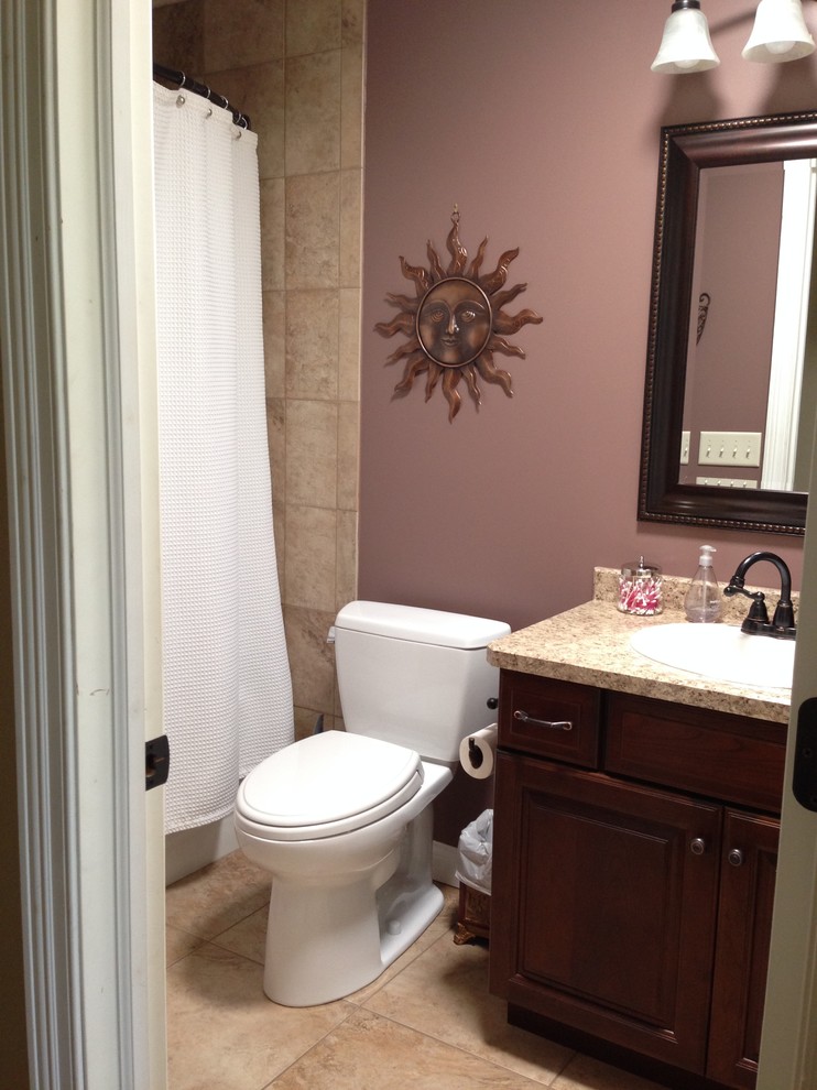 Traditional kids bathroom in Other with a drop-in sink, raised-panel cabinets, medium wood cabinets, laminate benchtops, a drop-in tub, an alcove shower, a one-piece toilet, beige tile, ceramic tile, purple walls and ceramic floors.