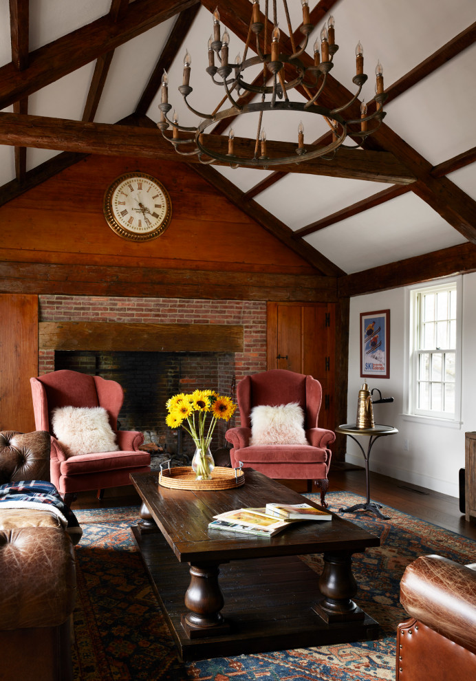 Inspiration for an expansive classic open plan living room in Boston with white walls, dark hardwood flooring, a standard fireplace, a brick fireplace surround, a freestanding tv, brown floors and exposed beams.