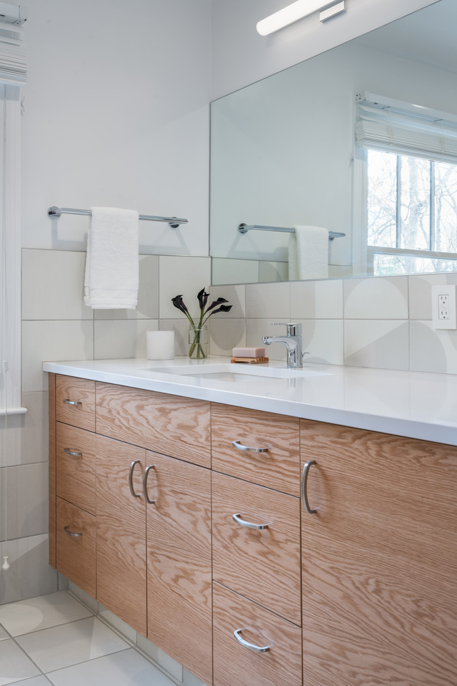 Mid-sized modern kids bathroom in Boston with flat-panel cabinets, medium wood cabinets, an alcove tub, a two-piece toilet, beige tile, porcelain tile, white walls, porcelain floors, an undermount sink, engineered quartz benchtops, beige floor and white benchtops.