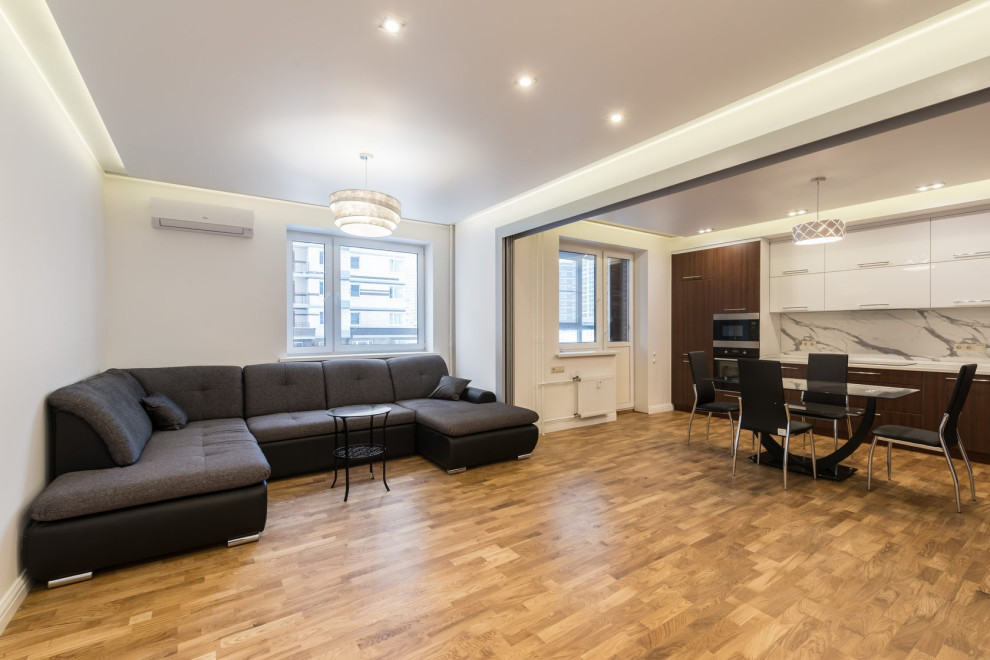 Foto di un grande soggiorno design aperto con pareti bianche, pavimento in laminato e pavimento beige