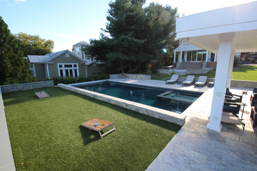 Large contemporary backyard rectangular natural pool in DC Metro with a pool house and natural stone pavers.