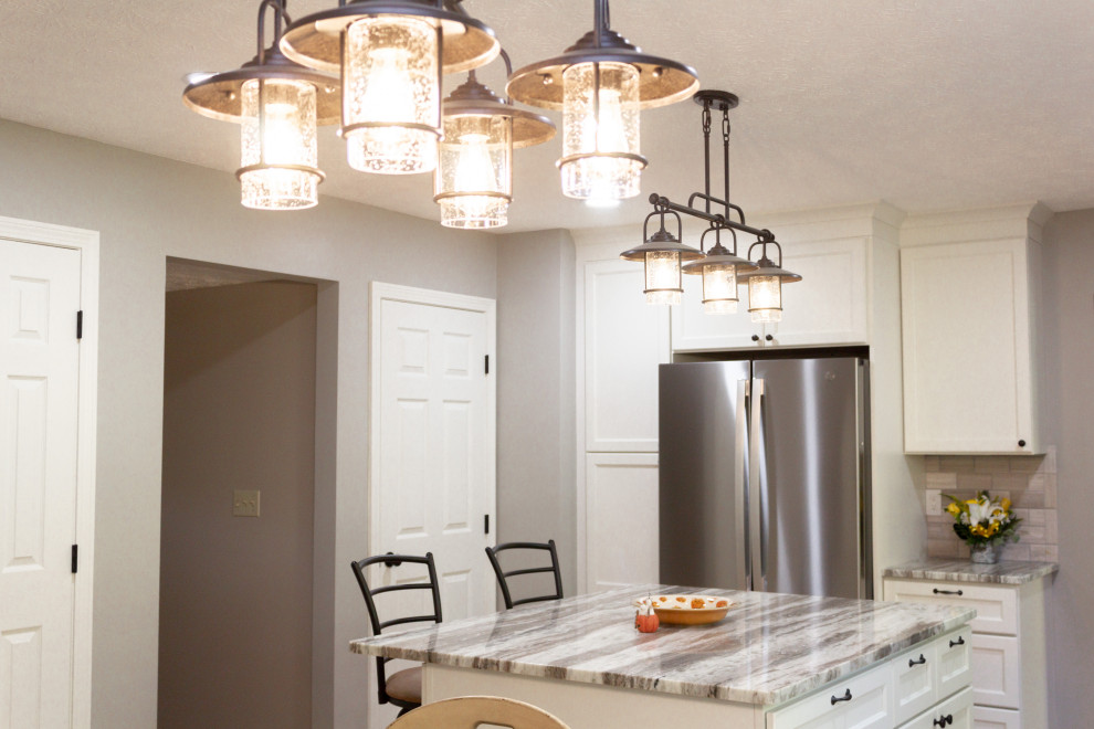 Kitchen - transitional l-shaped kitchen idea in Columbus with an undermount sink, white cabinets, gray backsplash, an island and gray countertops